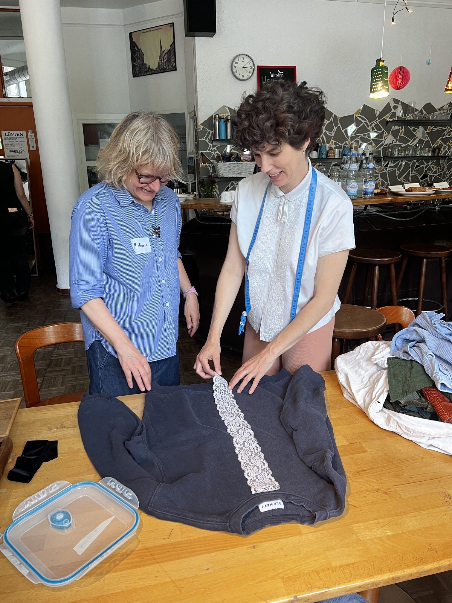 Two people examine a piece of clothing during a CARE Circular Clothing Pilot activity.