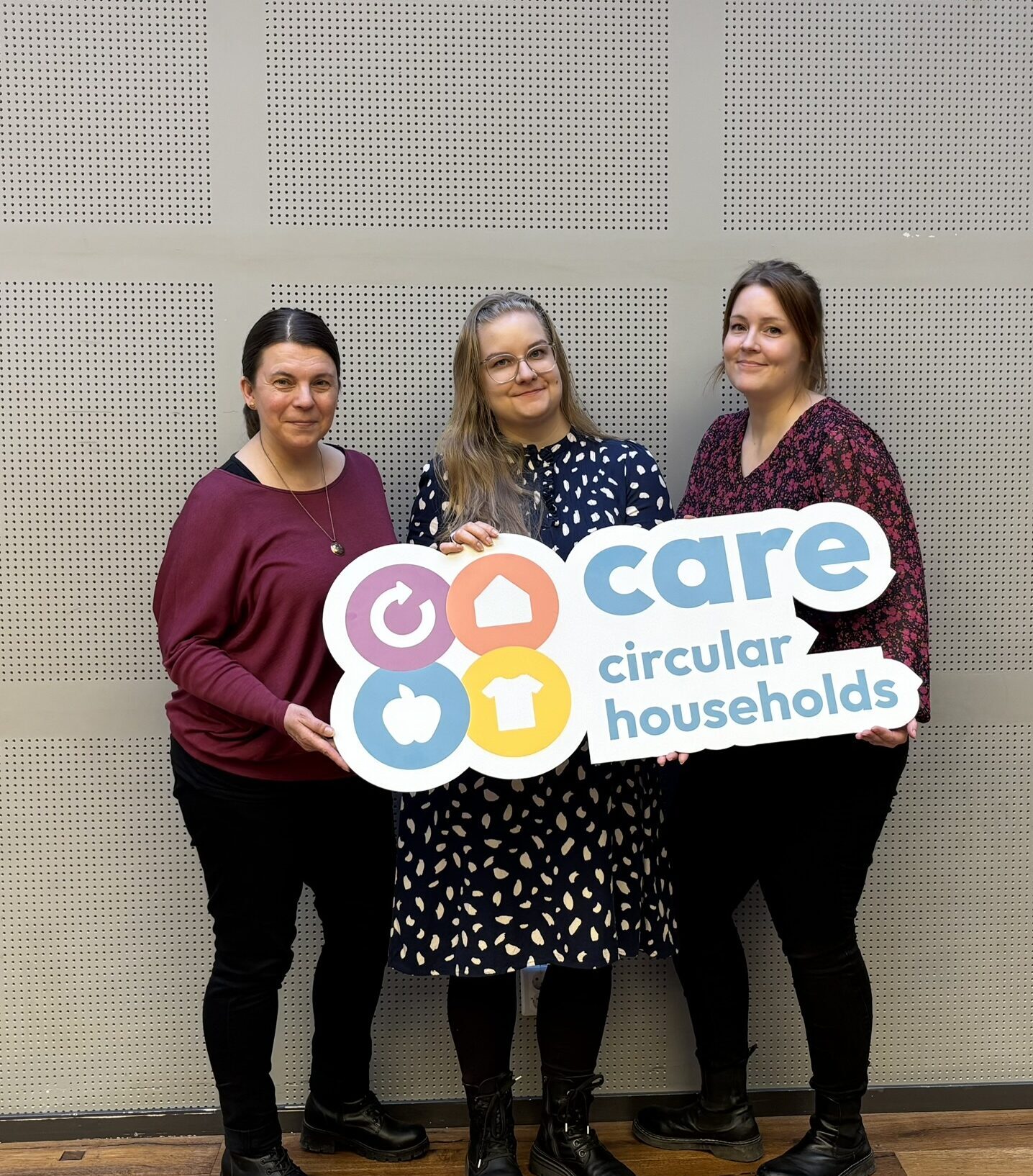 Sanna Teinilä, Jenni Nummila and Sanni Kouhi from Ecofellows holding a large CARE Circular Households sign.