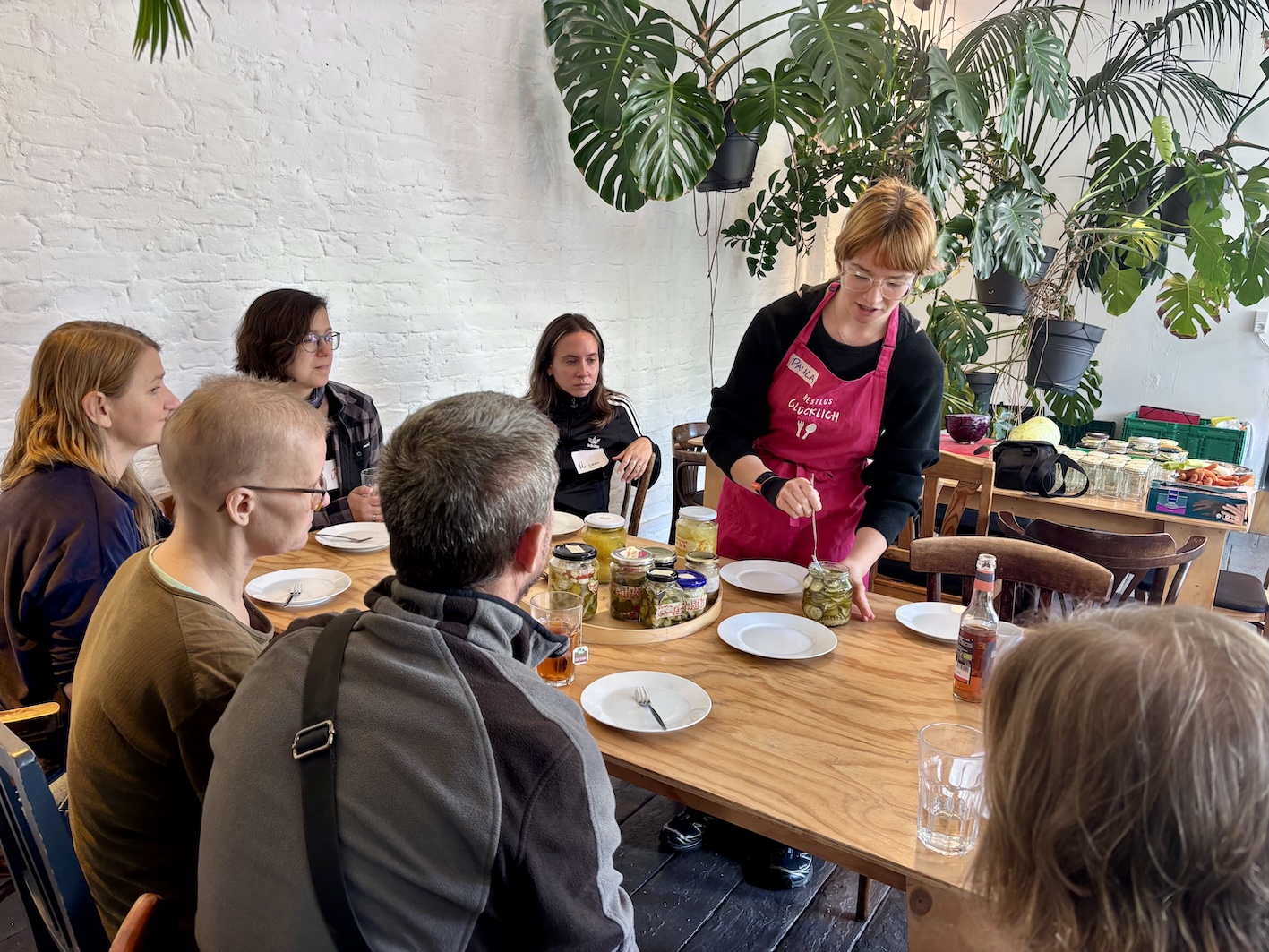 Workshop facilitator showing preserved vegetables to CARE households during a food storage workshop in Berlin