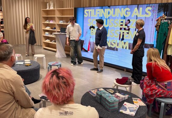 CARE household participants take part in a personal style workshop in Berlin, with facilitators, clothing racks and a presentation on conscious consumption.